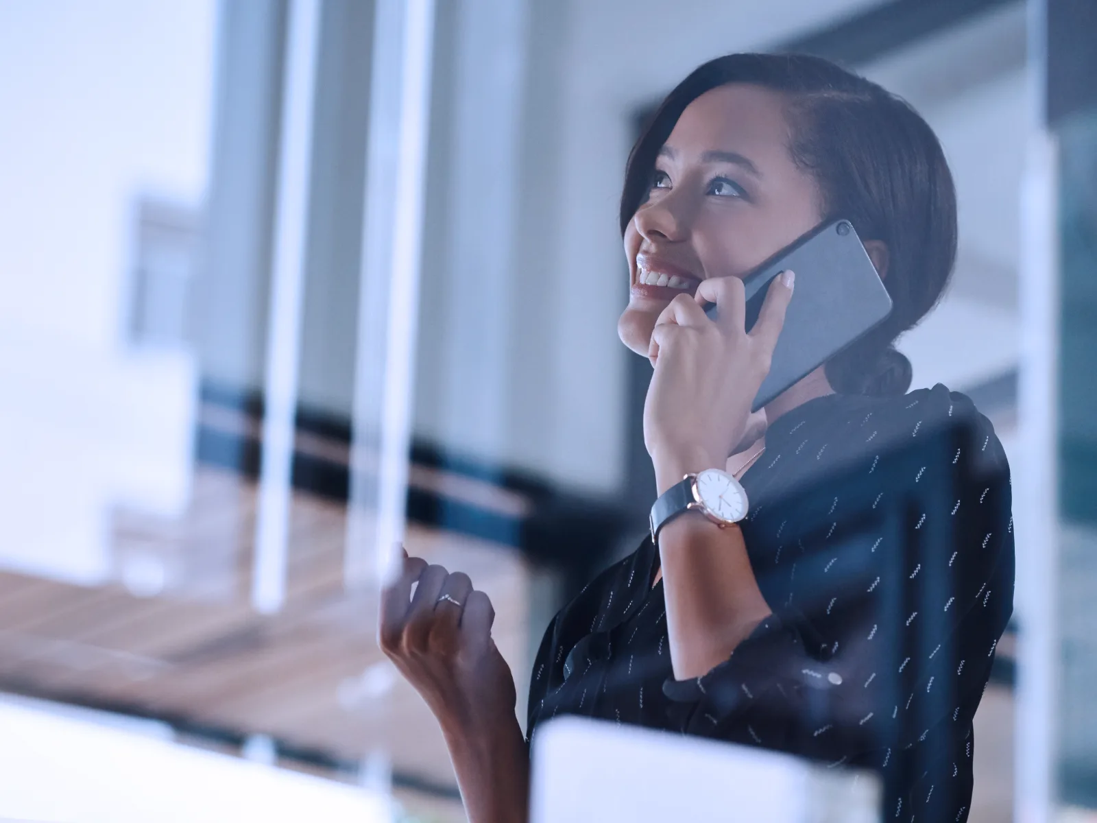 Insurance professional smiling on a call at her desk